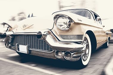about-04 A classic Cadillac captured in motion, showcasing its vintage charm and sleek design.