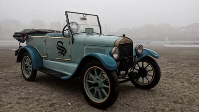 about-03 Classic blue convertible car captured in foggy Kolkata, India, evoking nostalgia.