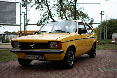 menu-03 Classic yellow Opel car parked outdoors in Minsk, showcasing retro style.