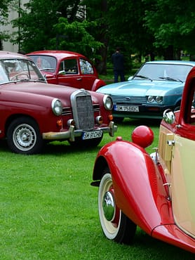 menu-08 A vibrant display of classic vintage cars at an outdoor exhibition.