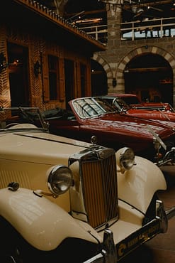 Showcase of beautifully preserved vintage cars in a classic indoor setting.